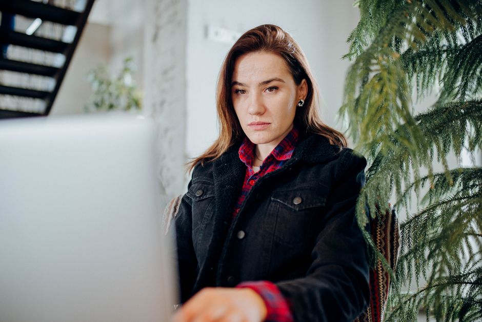 Jeune femme concentrée sur son ordinateur portable dans un bureau moderne