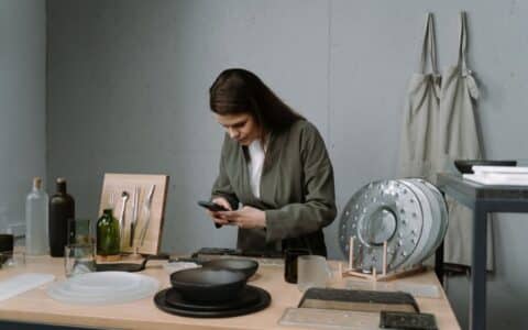 Artisane photographiant ses créations avec son téléphone dans son atelier