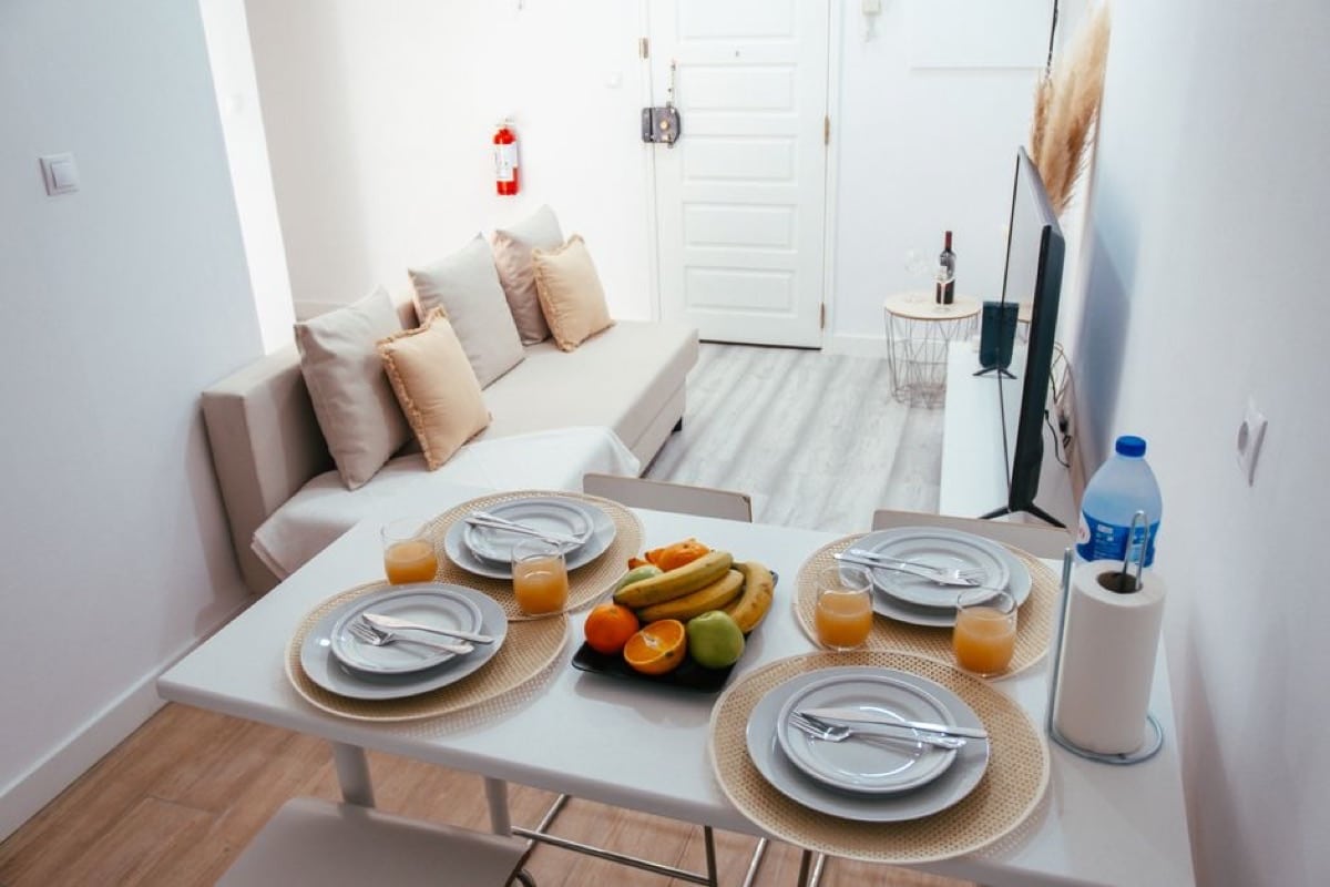 Table dressée et corbeille de fruits pour l'accueil des voyageurs dans un logement en location courte durée