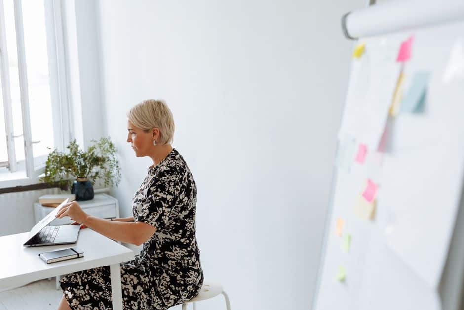 Femme d'une cinquantaine d'années travaillant sur son ordinateur portable dans un bureau moderne