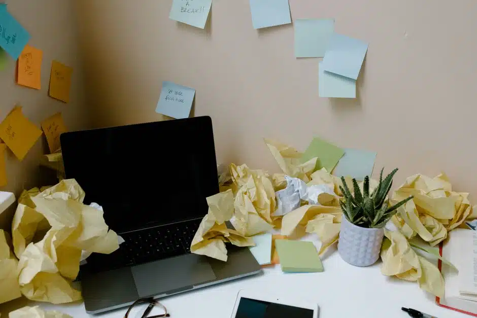 Bureau envahi de papiers froissés et de notes autocollantes, image de la surcharge d une boîte mail