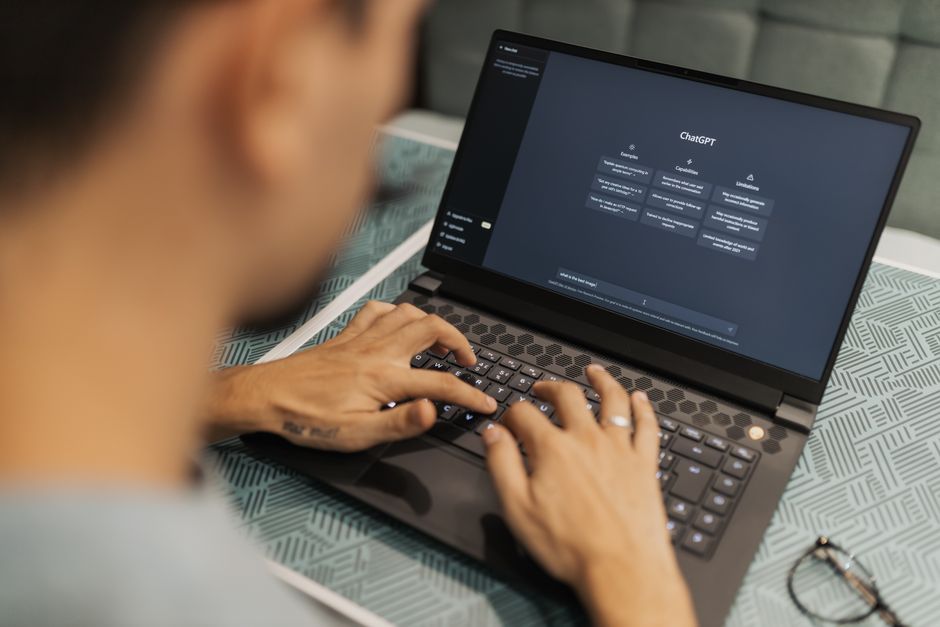 Professionnel qui utilise un assistant conversationnel base sur un grand modele de langage sur son ordinateur portable