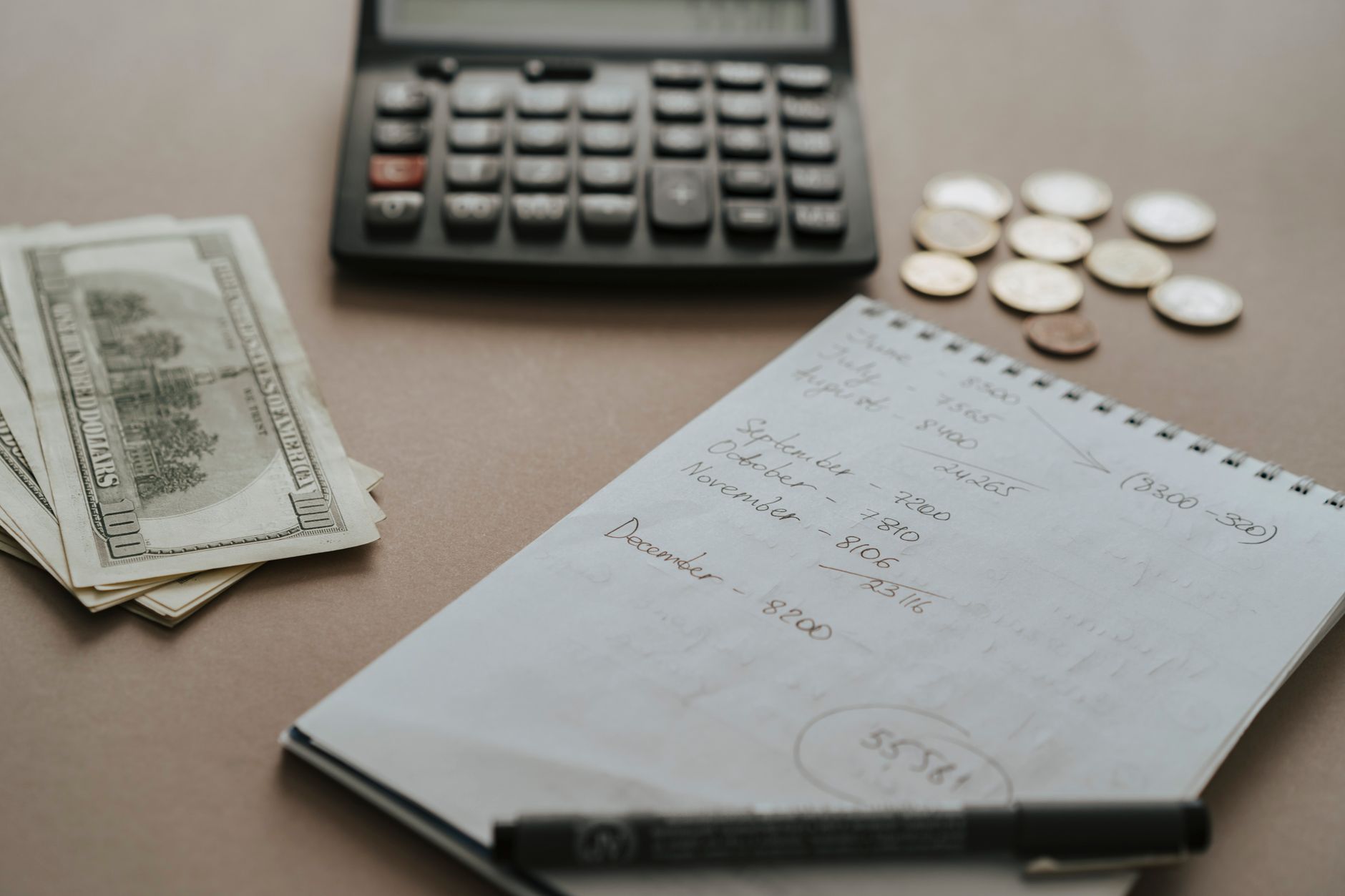 Calculatrice et carnet posés sur un bureau pour chiffrer un budget